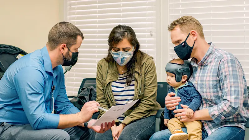 Parents consulting a Certified Prosthetist Orthotist on if a cranial remolding helmet is right for their child