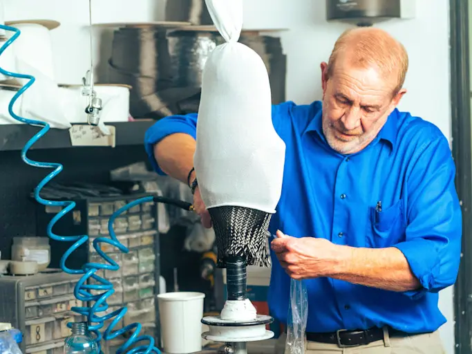 A prosthetic technician shaping a prosthetic device in a lab
