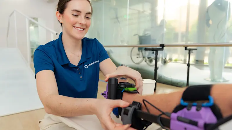 An Ottobock Care Certified Orthotist helping a patient into their orthotic device