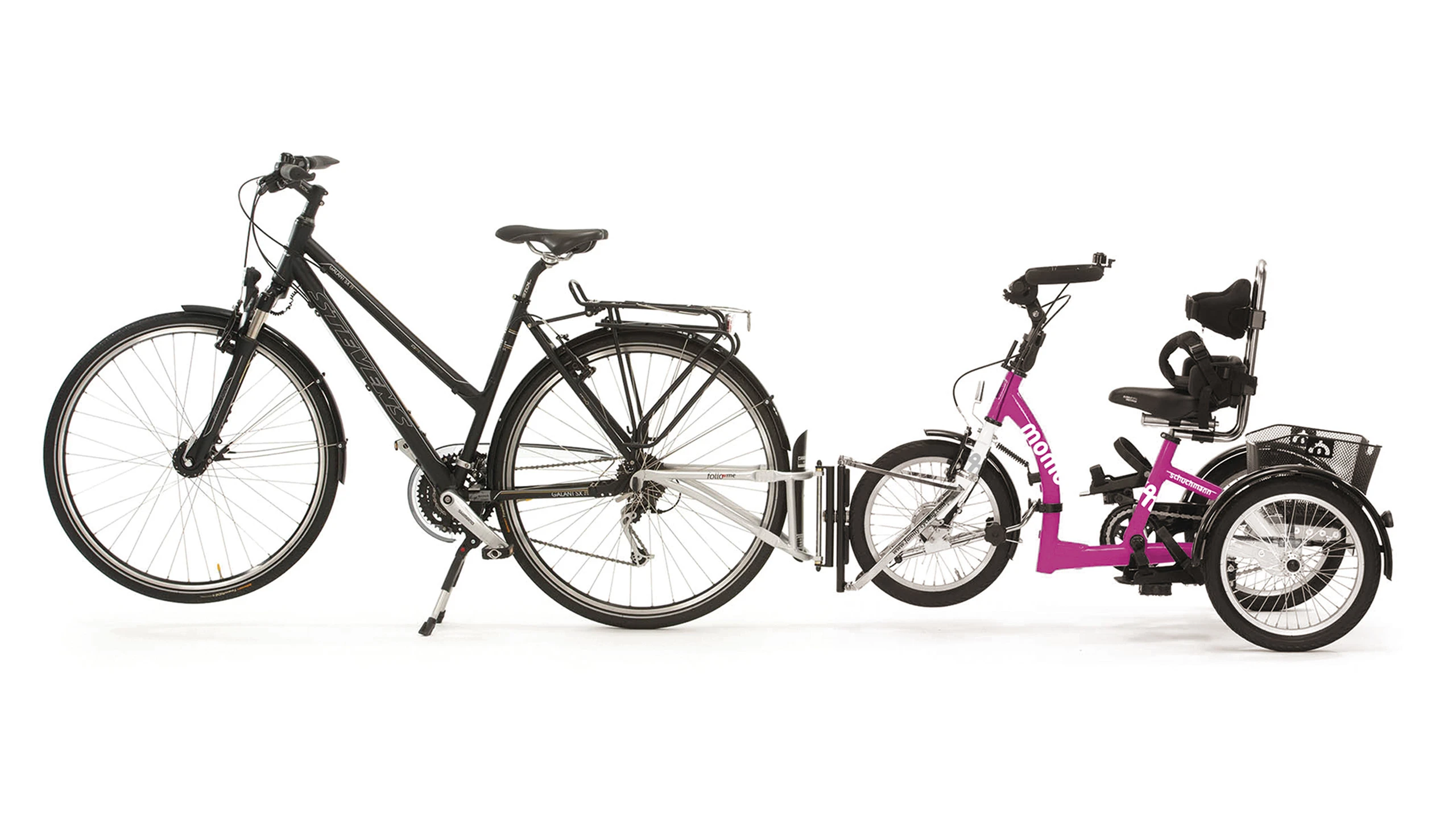 Immagine di un triciclo Momo agganciato a una bicicletta grazie all'accessorio FollowMe