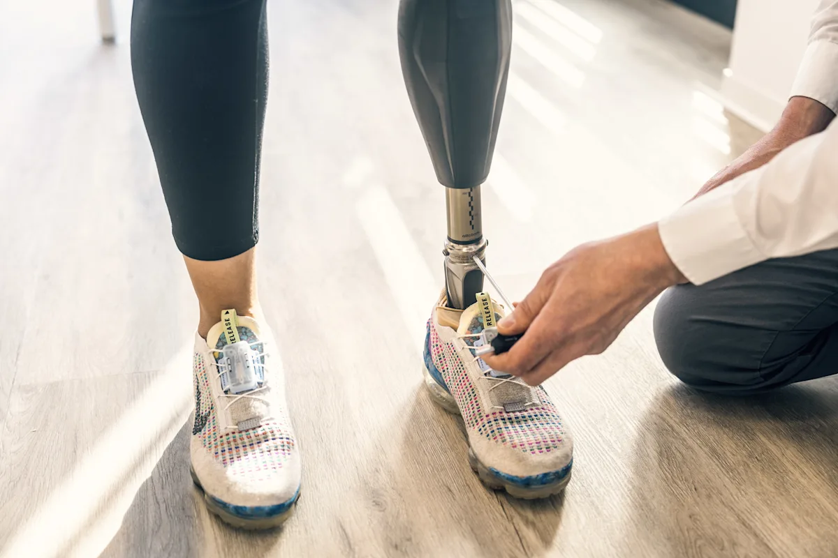 A prosthetic leg user's artificial limb being adjusted by a Certified Prosthetist Orthotist (CPO)