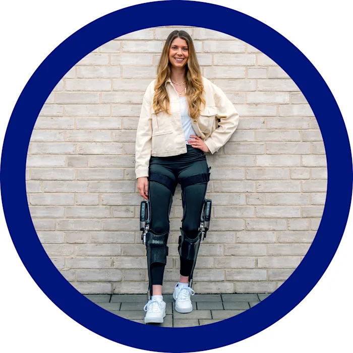 Una ragazza appoggiata al muro mentre indossa su entrambe le gambe l'ortesi a controllo C-Brace®