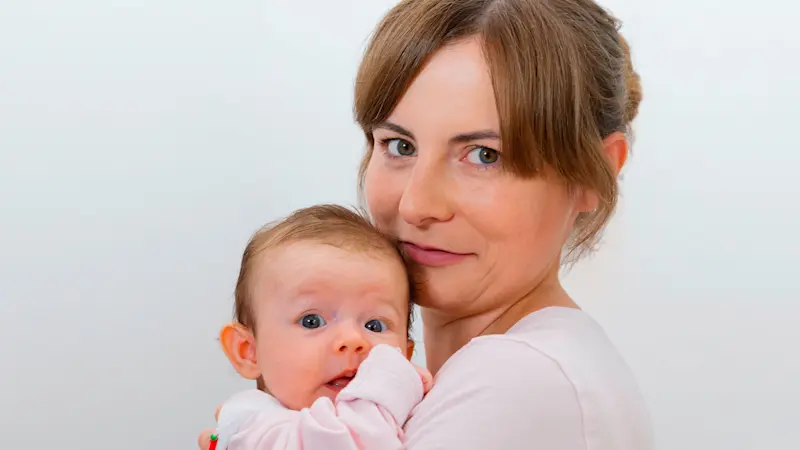 Una mamma abbraccia il suo bambino con addosso l'ortesi pediatrica Tubingen