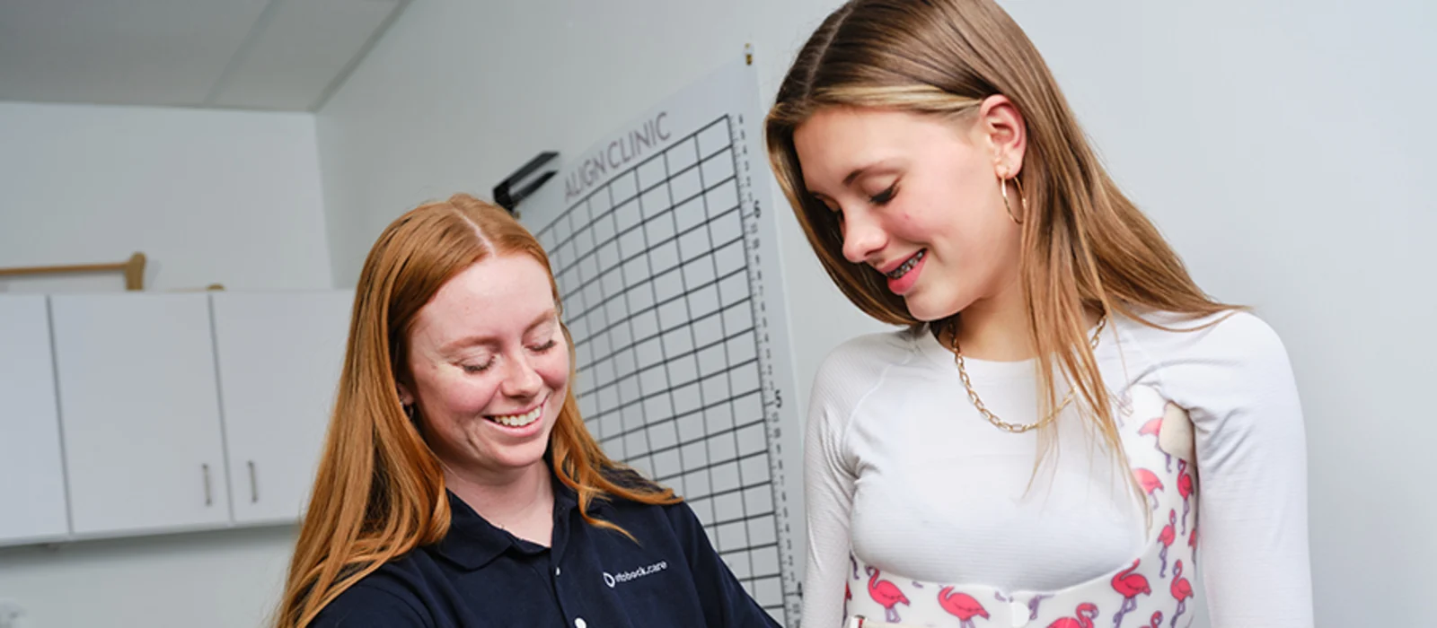 Un protésico certificado Ortocista que ayuda a un paciente con escoliosis a encajar en su ortodoncia correctiva espinal