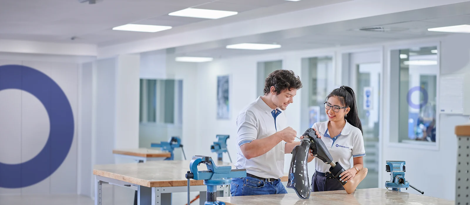 Dos ortocistas certificados (CPO) examinan una pierna protésica en un laboratorio de O&P