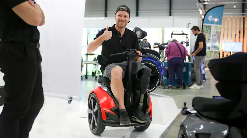 Un paziente amputato di gamba usa Genny Zero per muoversi in fiera