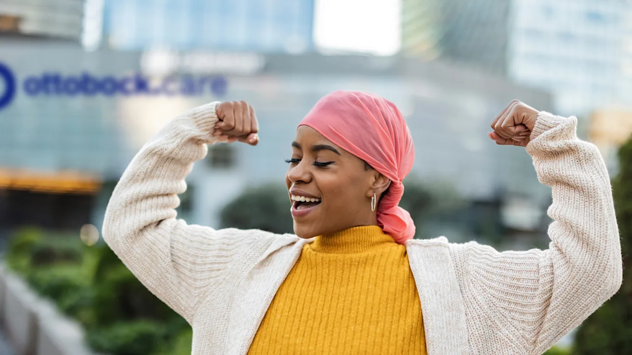 A Breast Cancer Survivor posing proudly in front of an Ottobock Care clinic