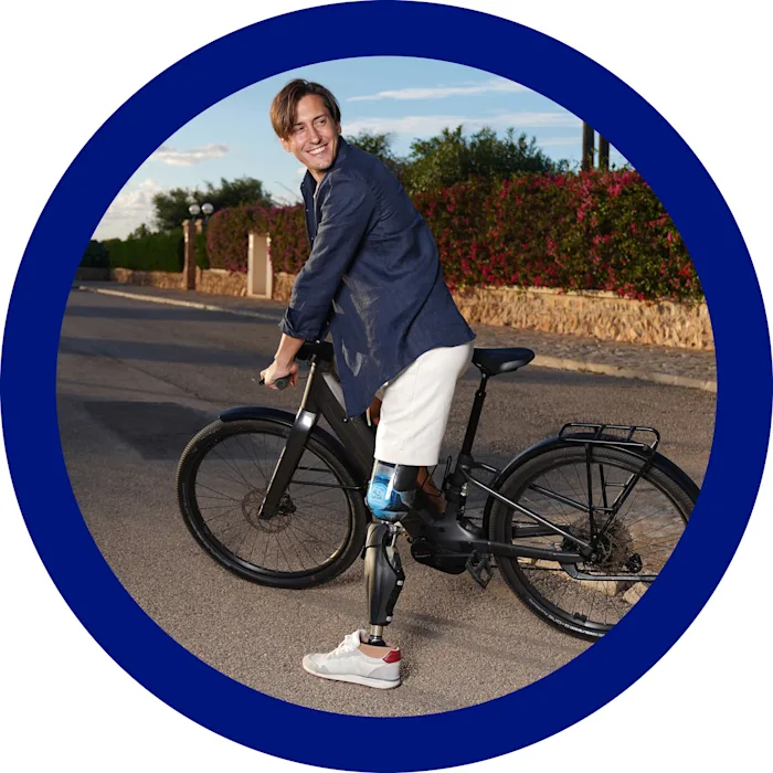 Un amputato transfemorale con ginocchio elettronico Genium X4 e piede protesico Evanto sorride in sella alla sua bicicletta