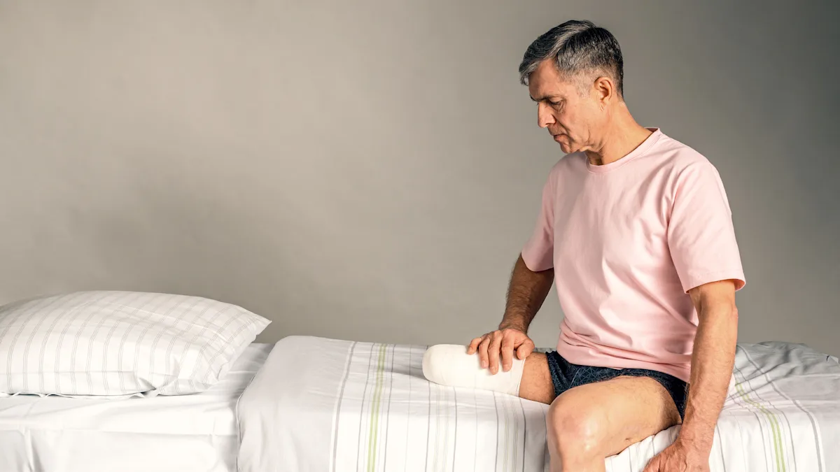 A leg amputee sitting on a bed resting their residual limb