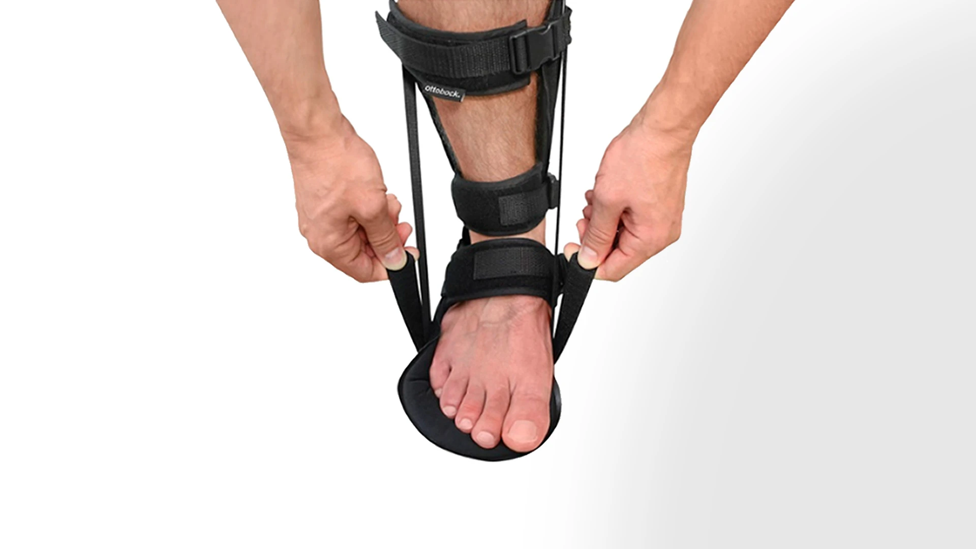 Due mani che stringono le chiusure a velcro mostrano come si indossa l'ortesi Malleo Immobil Night Splint