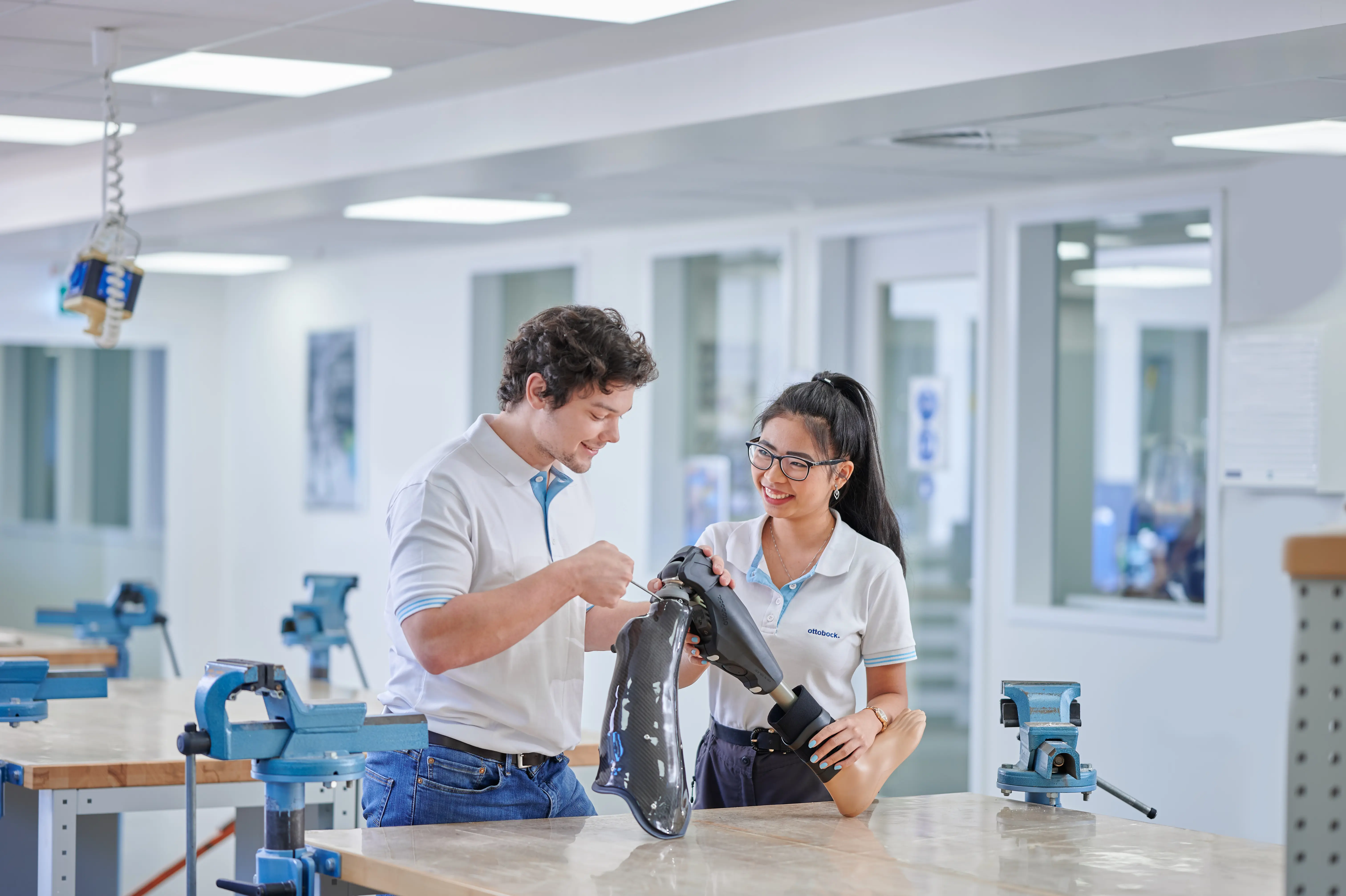 Prosthetic technician professionals reviewing an artificial leg in a lab