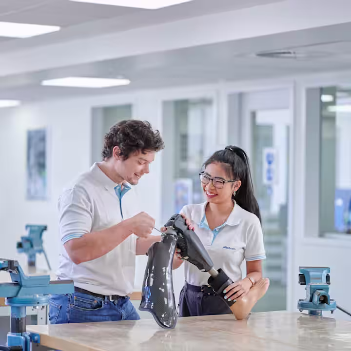 Profesionales técnicos protésicos revisando una pierna artificial en un laboratorio