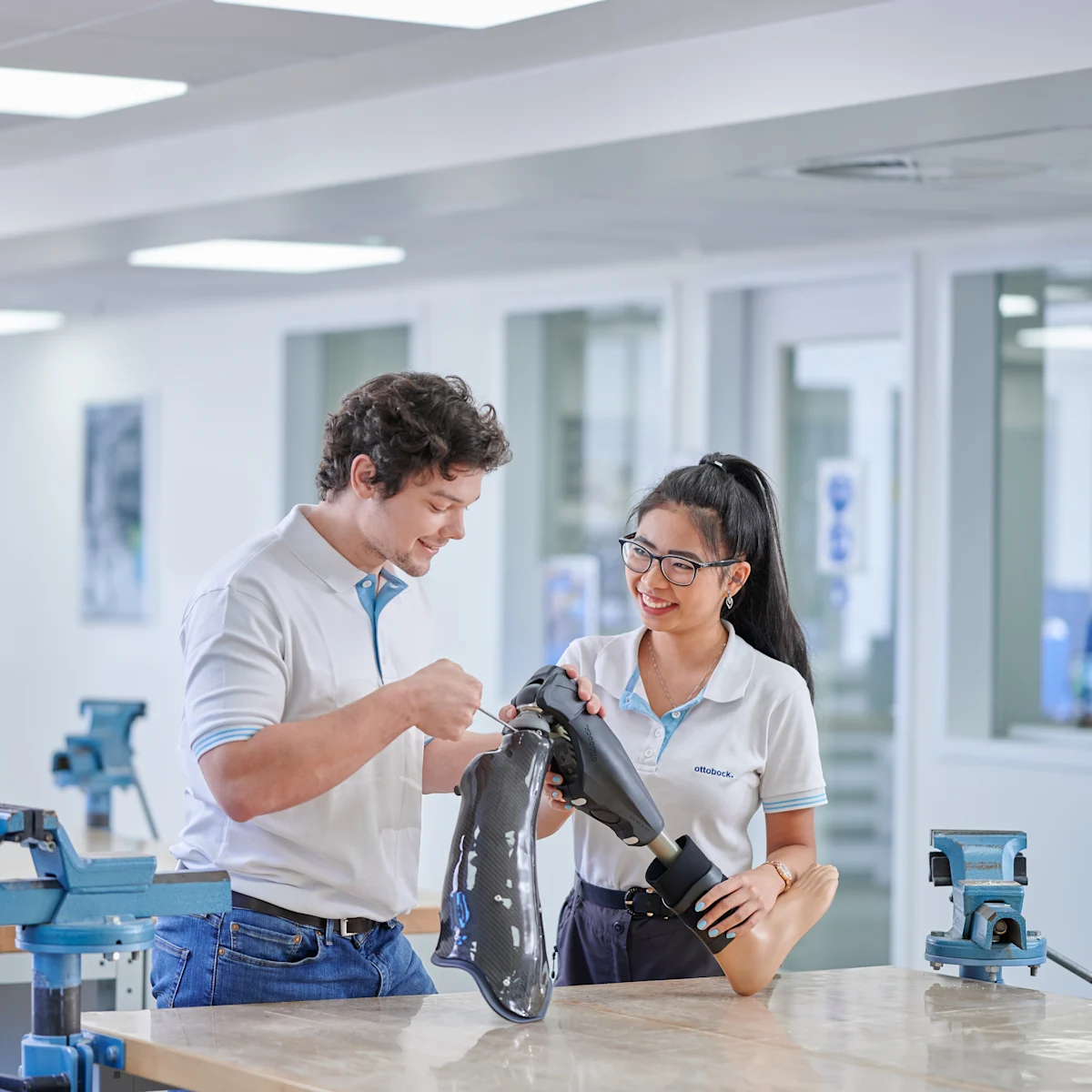 Profesionales técnicos protésicos revisando una pierna artificial en un laboratorio