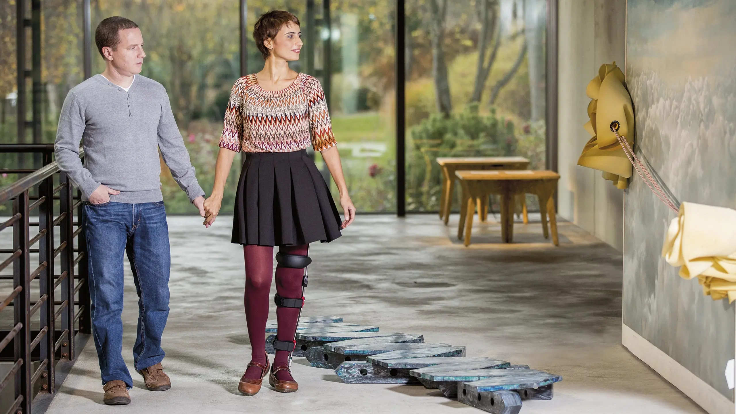 Una paziente con ortesi FreeWalk passeggia mano nella mano con il compagno in un museo