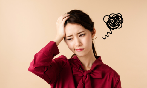 頭に手をあて悩んでいる女性