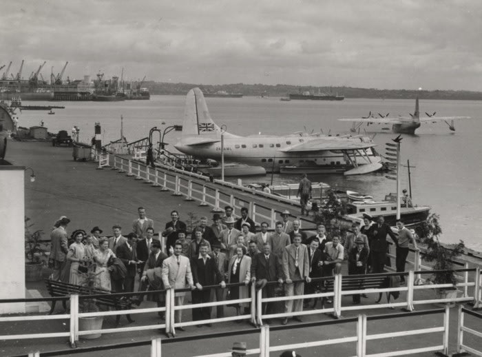 Passengers waiting to board TEAL Solent R.M.A. Aotearoa II, ZK-AML at Mechanics Bay, March 1950. Whites Aviation Limited. Mar 1950. TEAL Solent ZK-AML, 15–0462. Walsh Memorial Library, The Museum of Transport and Technology (MOTAT).