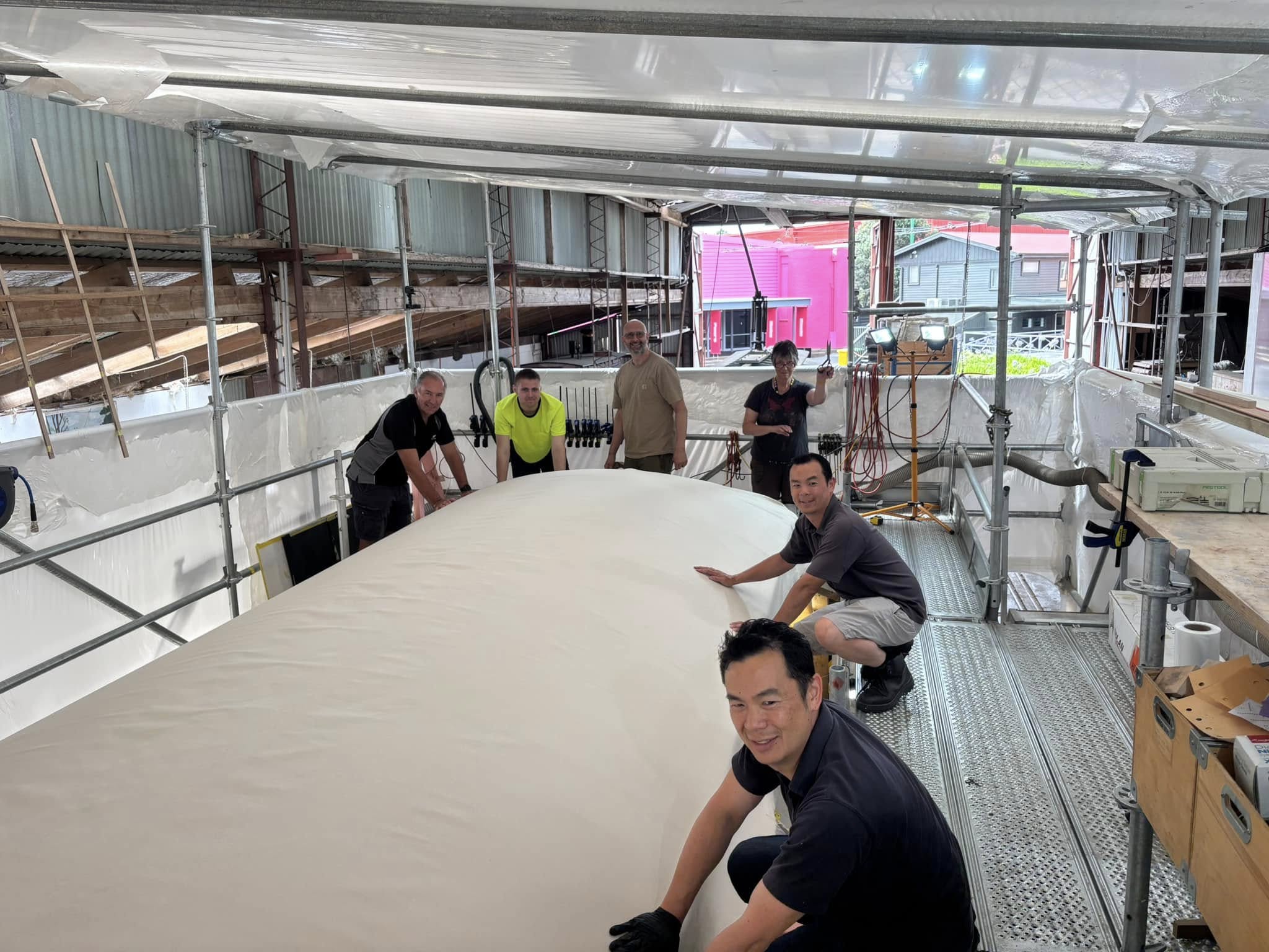 A single piece of  12oz cotton duck canvas is stretched over the roof by the whole team.