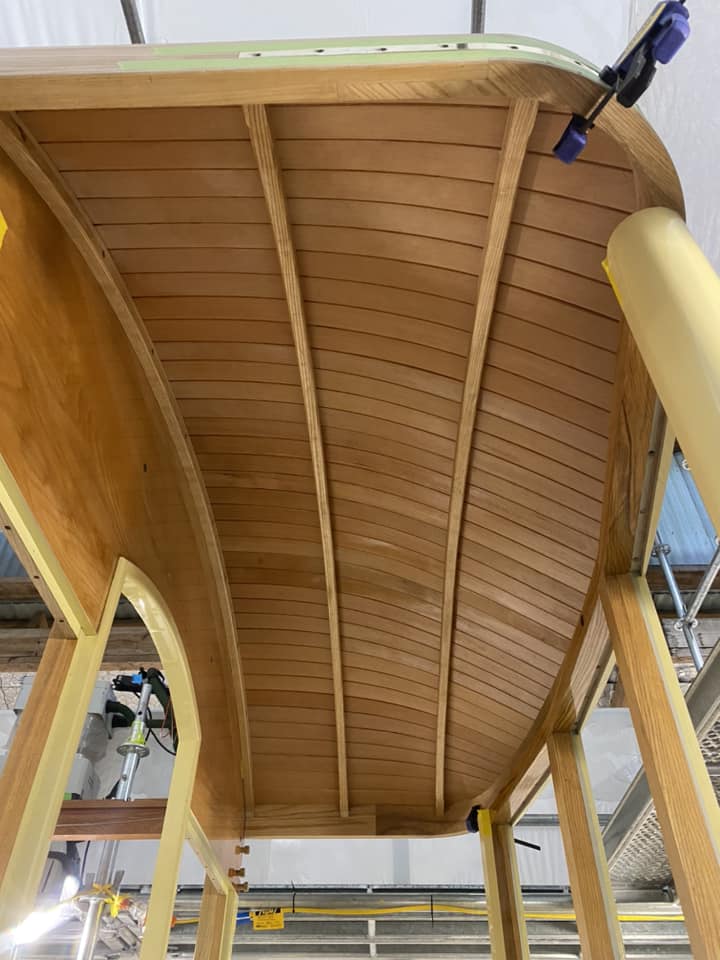 The planked underside of the curved vestibule ends are primed prior to install and here shown finished and satin clear coated.