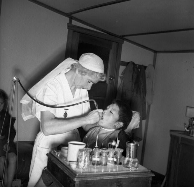 dental nurse giving a boy treatment 1944