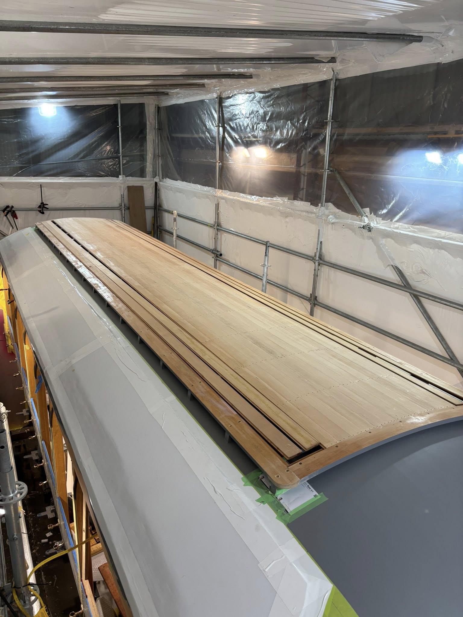 The planking process of the lapped Oregon is repeated over the totara roof bows and almost complete.