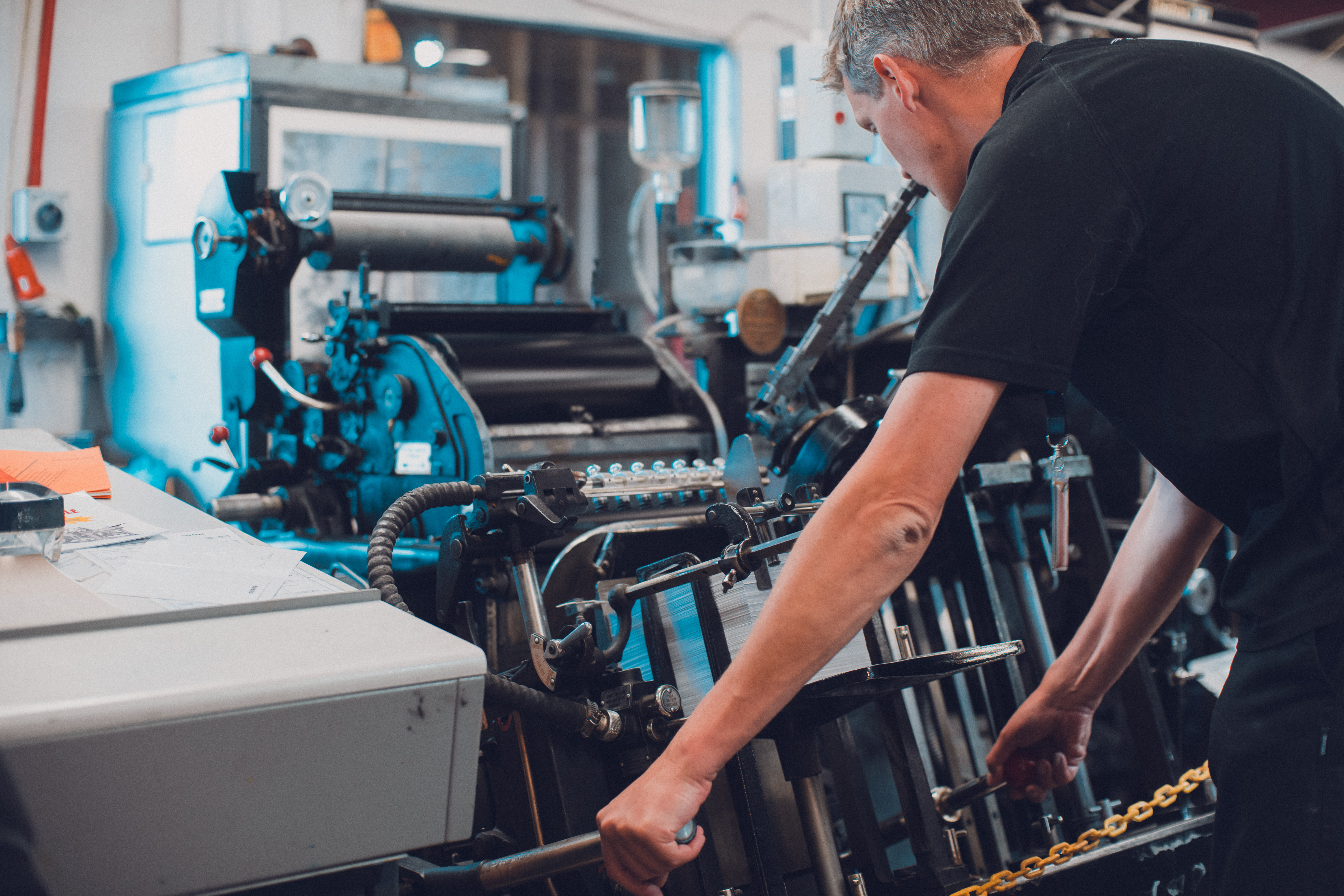 Print shop volunteer operating a Heidelberg press.