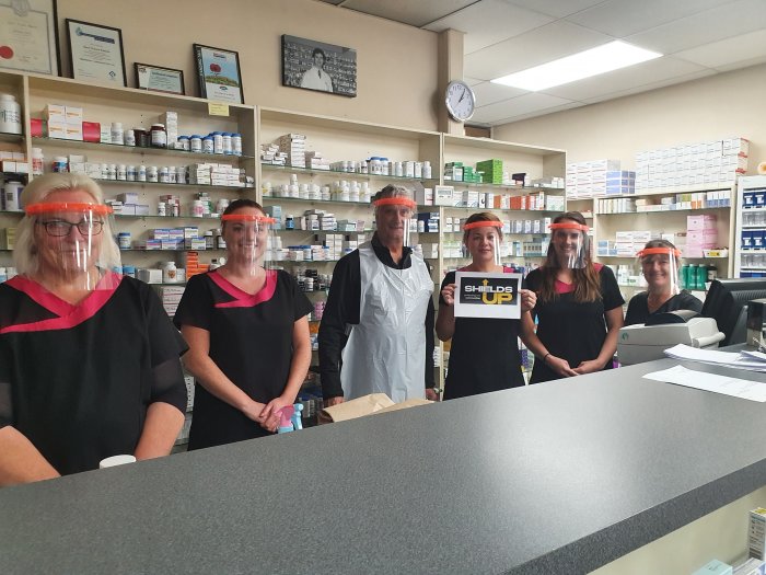 A pharmacy team wearing their ShieldsUp face shields during lockdown. 
