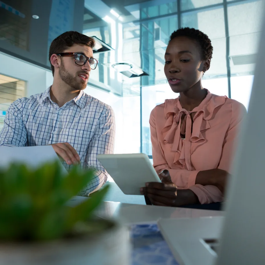 square-executives-discussing-over-digital-tablet-at-desk-in-office