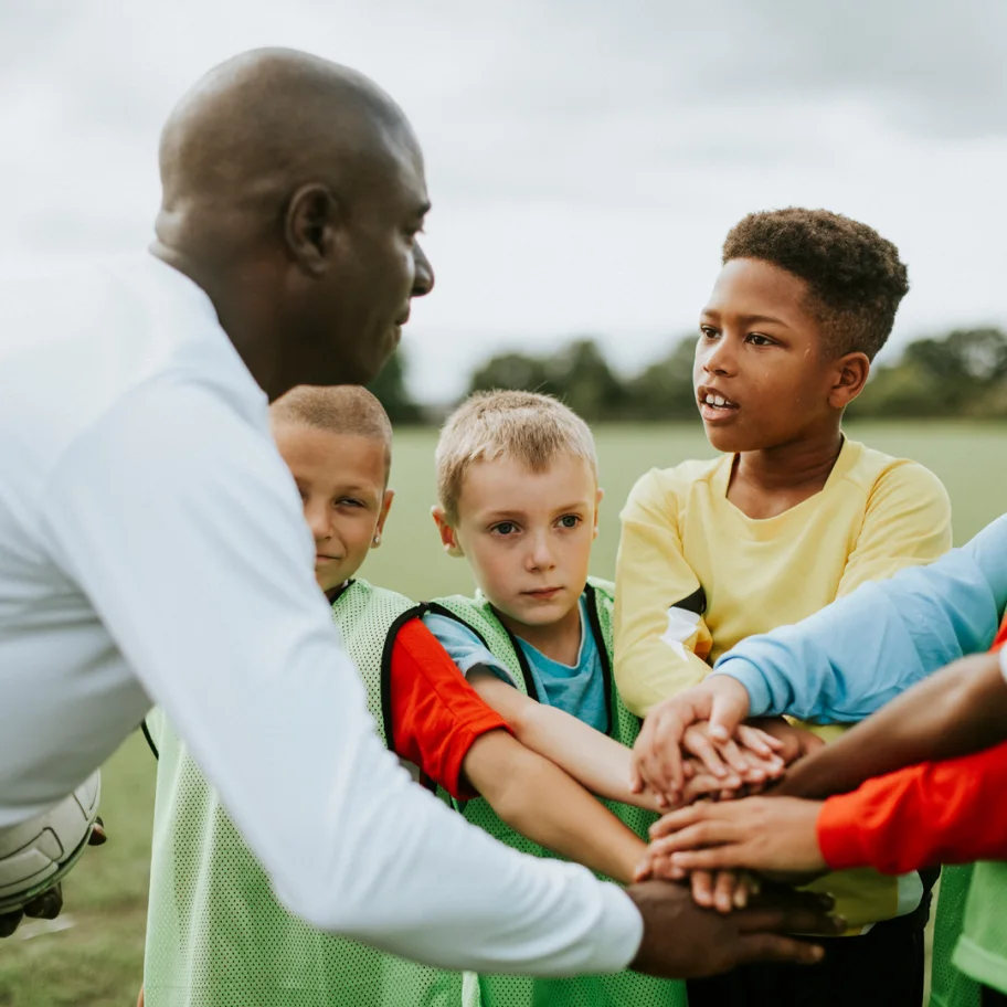 square-junior-football-team-stacking-hands-before-a-match