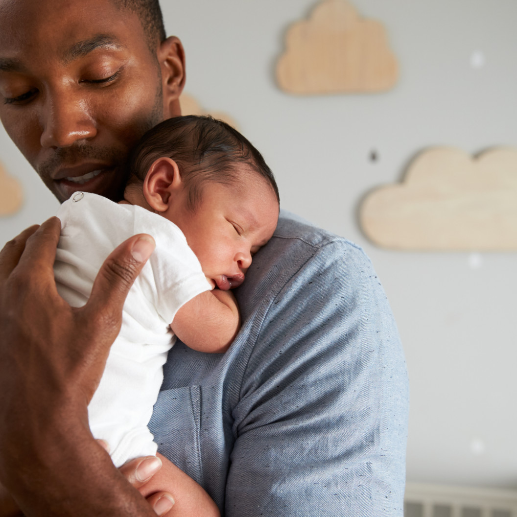 square-father-holding-newborn-baby-son-in-nursery