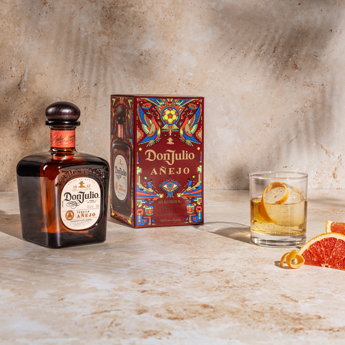Tequila Don Julio Anejo Old Fashioned cocktail next to a Tequila Don Julio Anejo Summer of Mexicana box designed by Raul Urias.