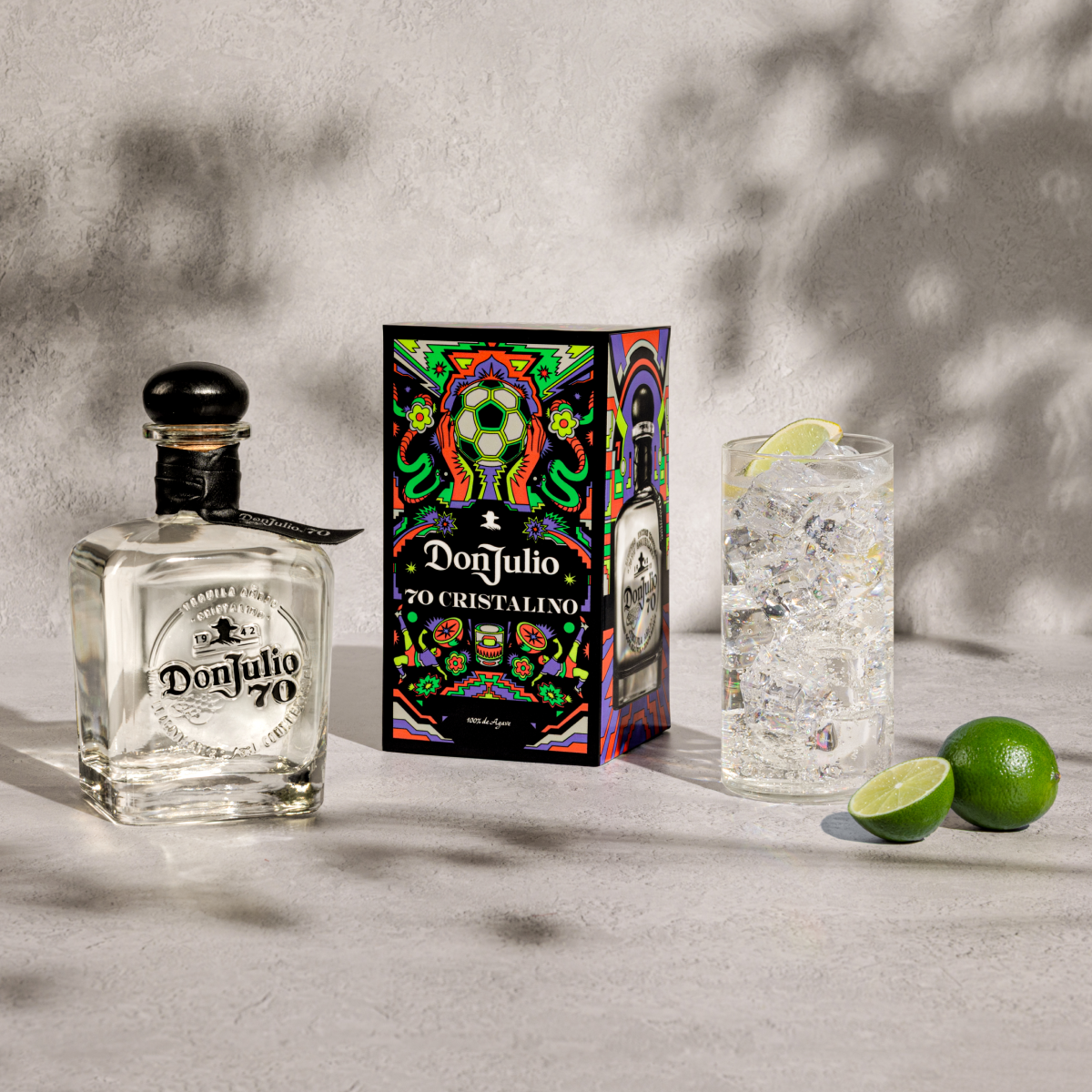 Tequila Don Julio 70 & Soda cocktail next to a Tequila Don Julio 70 Cristalino Summer of Mexicana box designed by Raul Urias.