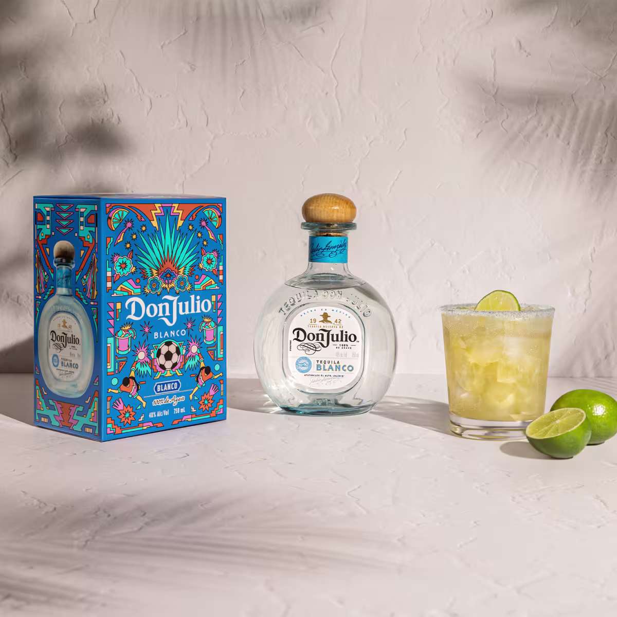 Tequila Don Julio Blanco Margarita cocktail next to a Tequila Don Julio Blanco Summer of Mexicana box designed by Raul Urias. 