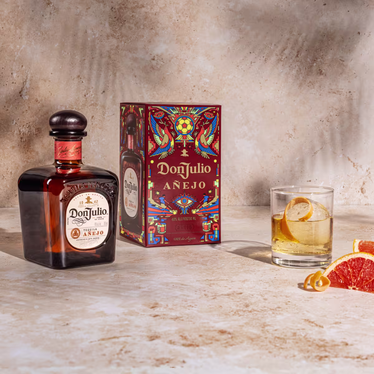 Tequila Don Julio Anejo Old Fashioned cocktail next to a Tequila Don Julio Anejo Summer of Mexicana box designed by Raul Urias. 