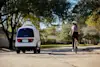 Woman bicycling in line with a Nuro vehicle