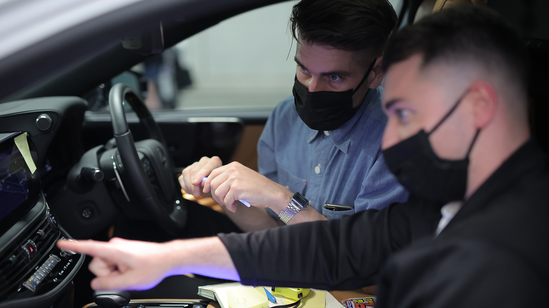 車内でインフォテインメント画面を確認する二人の男性