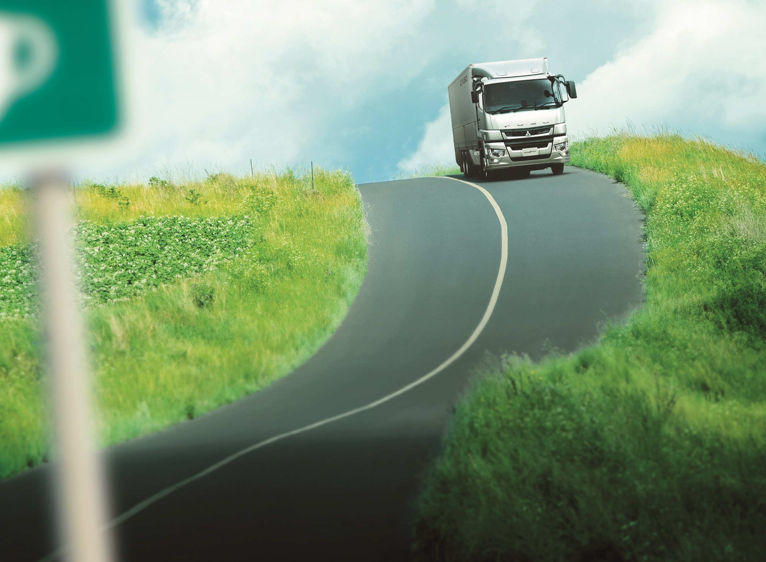 田舎道を走る三菱ふそうのトラック