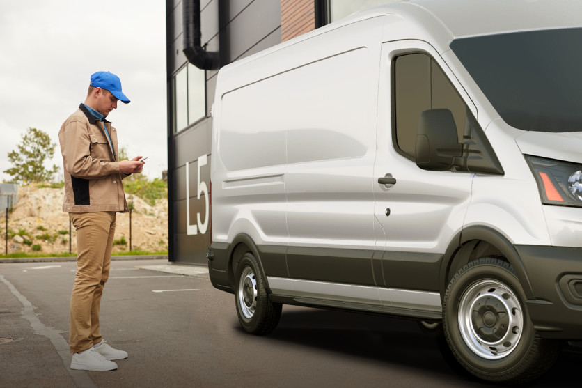 バンの外でスマートフォンを使用する男性