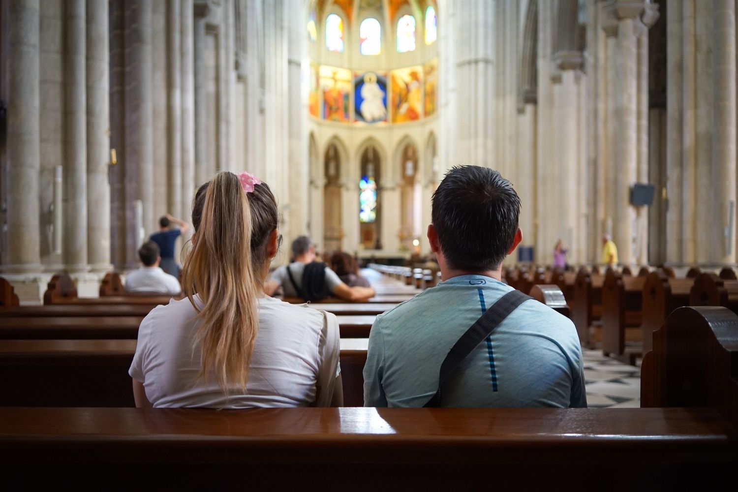 Auf dem Foto sitzen zwei junge Menschen im Gottesdienst.