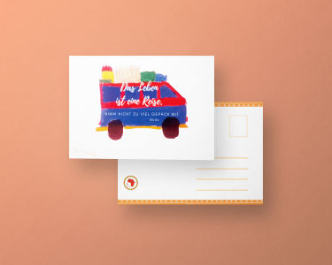 Zu sehen ist ein Bild einer Postkarte. Auf dieser sieht man einen kleinen bunten Bus der von einem Kind gemahlt wurde und darauf der Text geschrieben:" Das Leben ist eine Reise. Nimm nicht zu viel Gepäck mit.". 