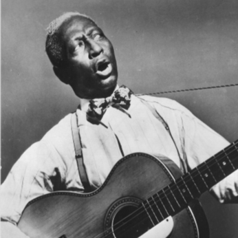 Description: Lead Belly singing, playing guitar