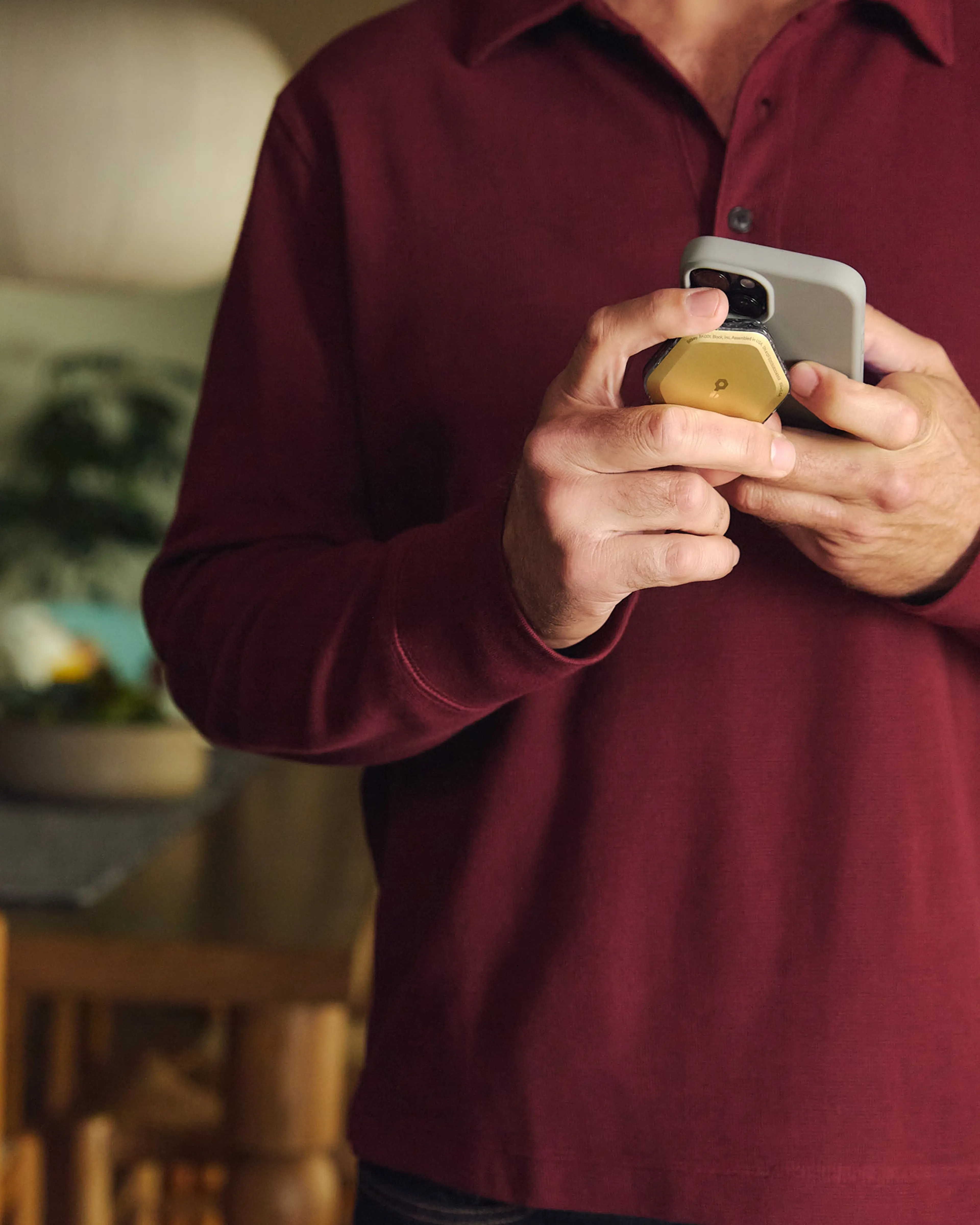 A man holding a phone and Bitkey device next to each other