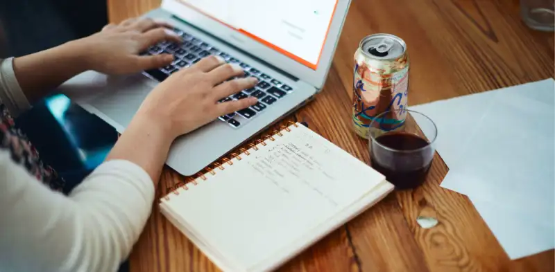 woman typing OKRs on laptop, goal setting on a laptop