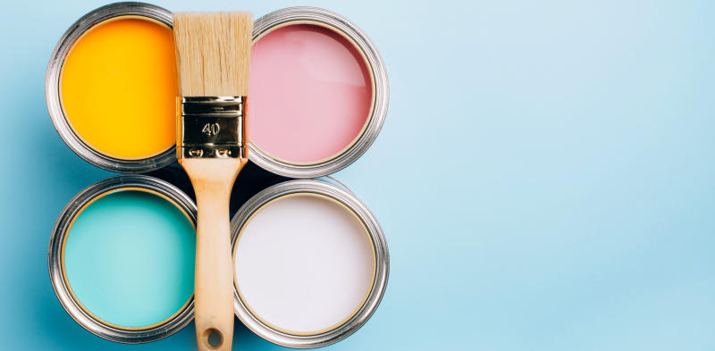 four open cans of paint with a brush on top of them on blue background