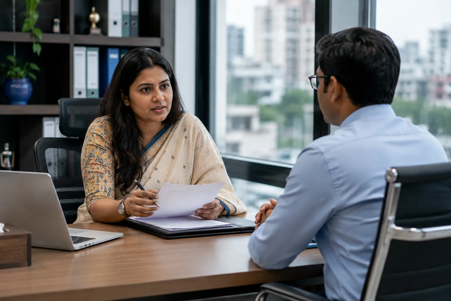 An HR professional is conducting a structured job interview with a candidate in an office setting.