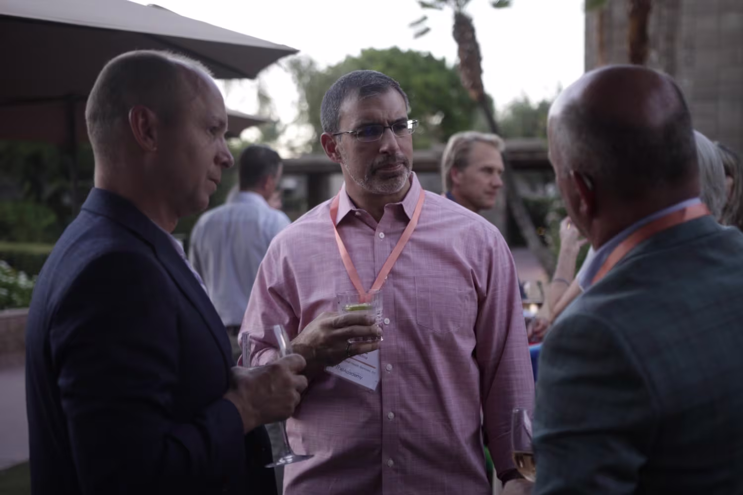 Group of senior healthcare executives networking at an exclusive healthcare CEO conference.