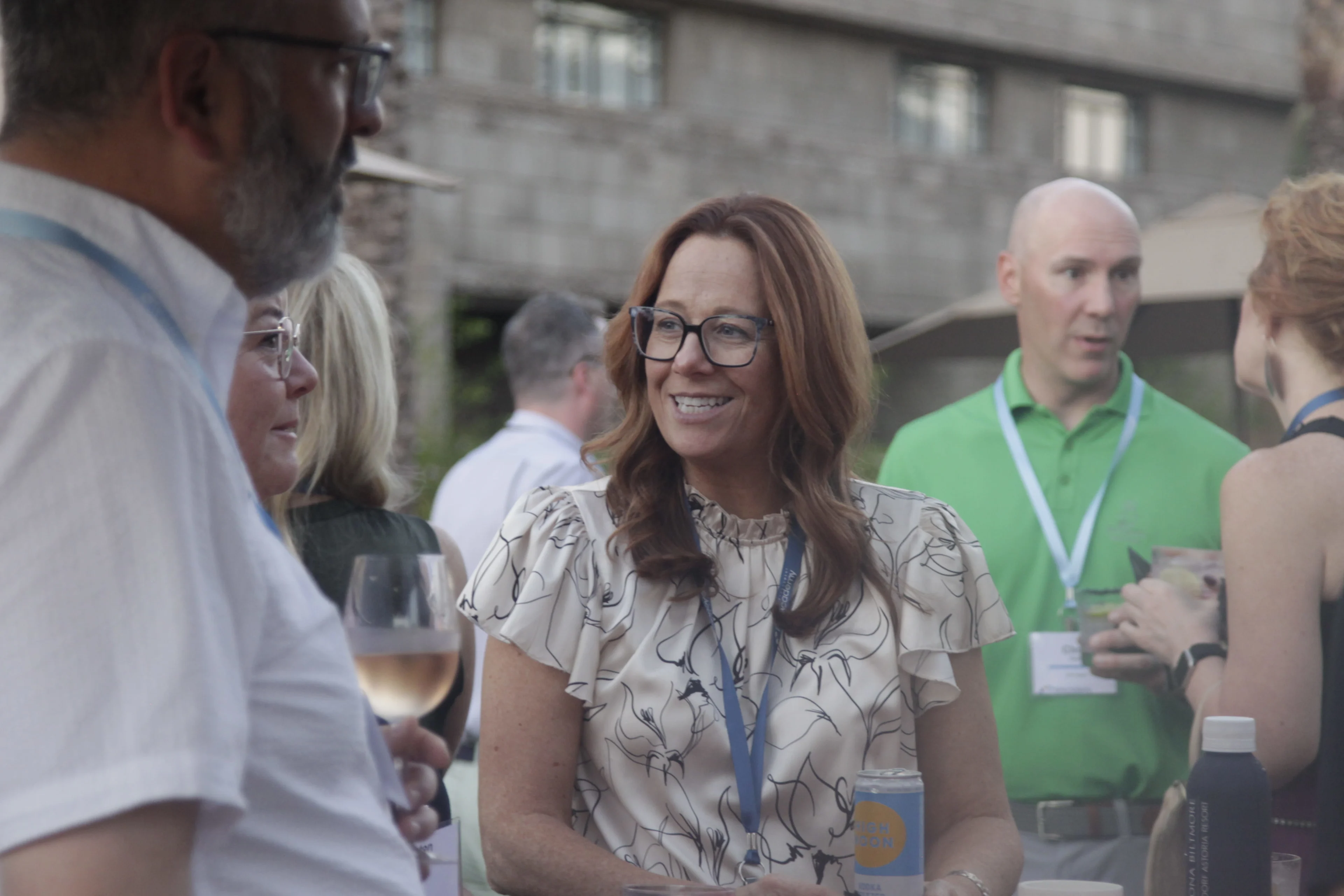 Healthcare executives and Chief AI Officers engaging in casual, collaborative networking during an outdoor reception at the THMA Chief AI Officer Forum.