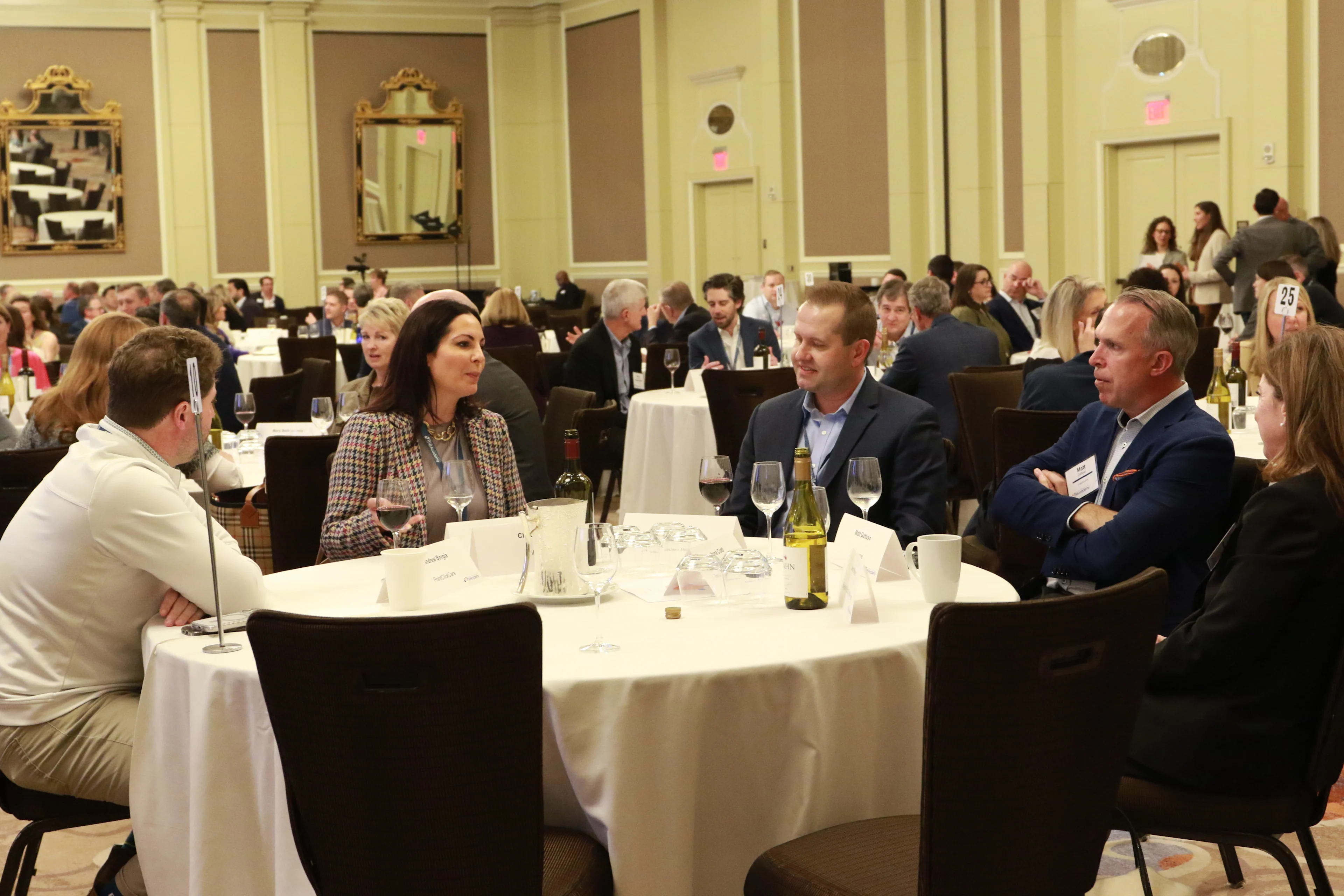 Healthcare executives networking and conversing at a banquet dinner during an industry conference.