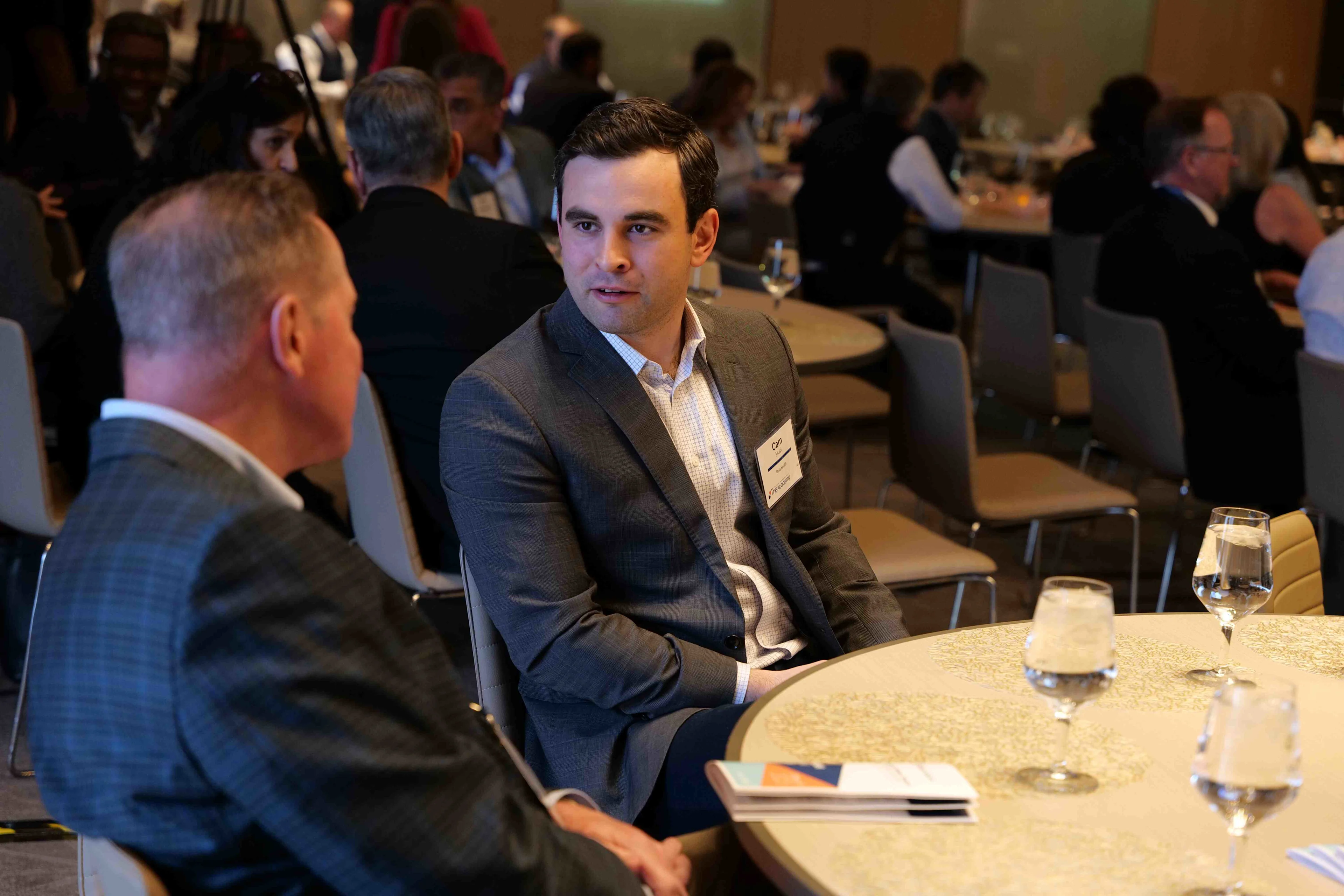 Two healthcare executives share industry knowledge at a healthcare leadership event