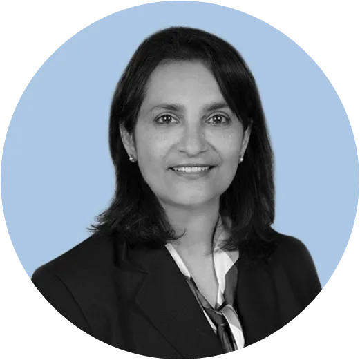 A grayscale portrait of a woman wearing a blazer and scarf, smiling slightly, set against a circular light blue background.