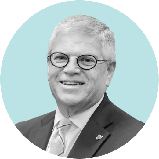 Grayscale portrait of a smiling man in a suit and tie, wearing round glasses, set against a circular teal background.